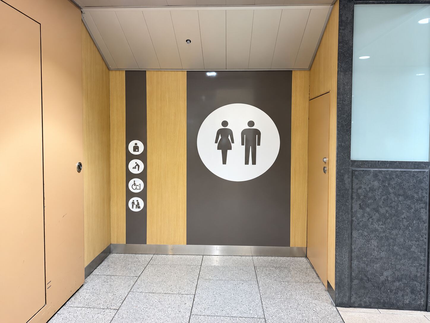 Accessible toilet with wheelchair, baby-seat and ostomate pictograms near the Central Exit (Chuo-guchi) of Nagoya Station, a second angle.