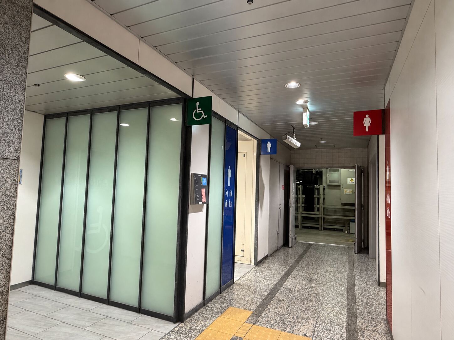 Accessible toilet stall with wheelchair, baby-seat and ostomate pictograms near the Sakura-dori side of Nagoya Station.