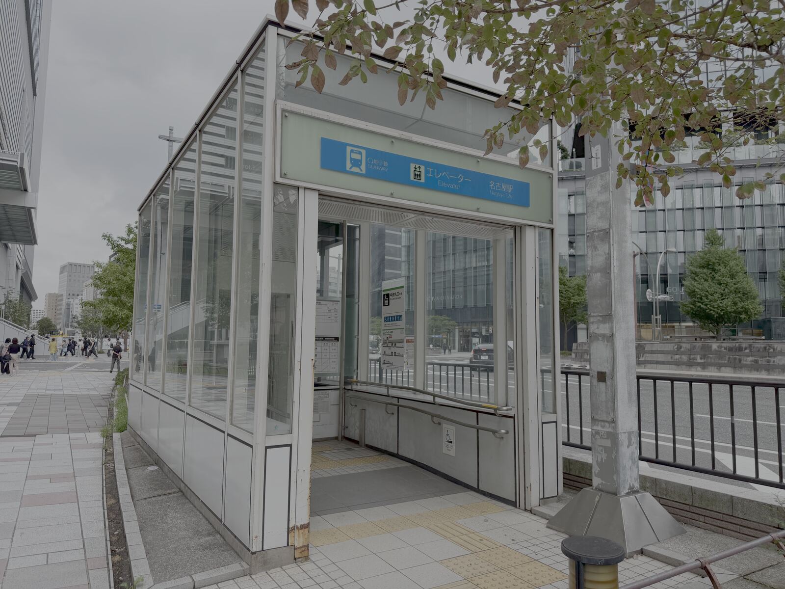 Glass-walled street-level subway elevator kiosk at Nagoya Station's Central Gate, on the Sakura-dori side.