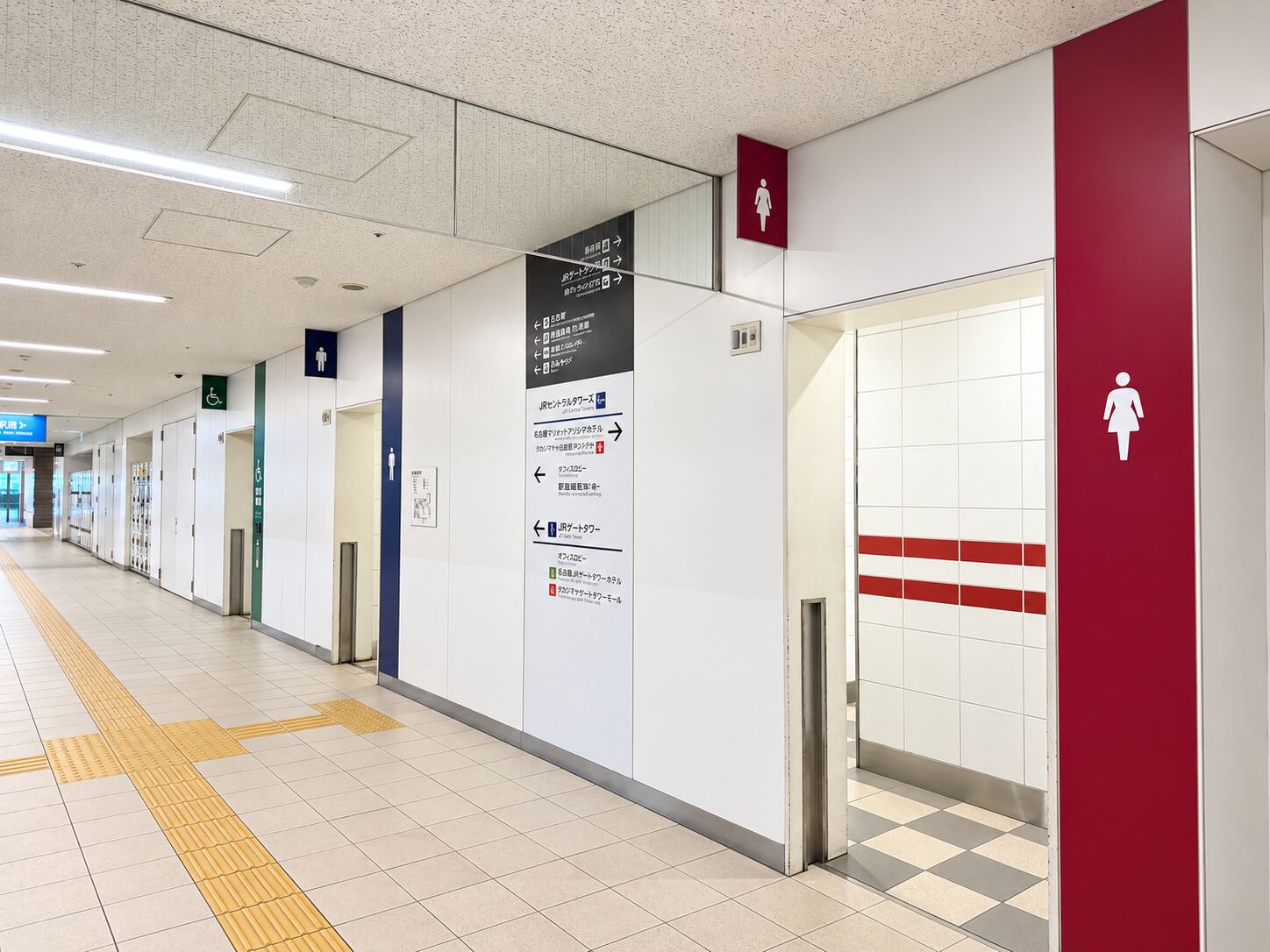Men's and women's toilet signs in the corridor near the Nagoya Station bus terminal, an approach view.