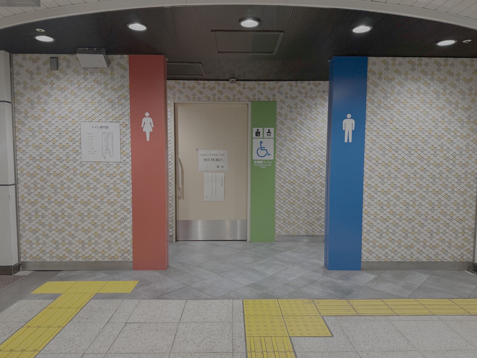 Universal Access Toilet entrance near the Higashiyama Line South Gate at Nagoya Station, with red and blue gender columns and a wheelchair-accessible toilet sign.