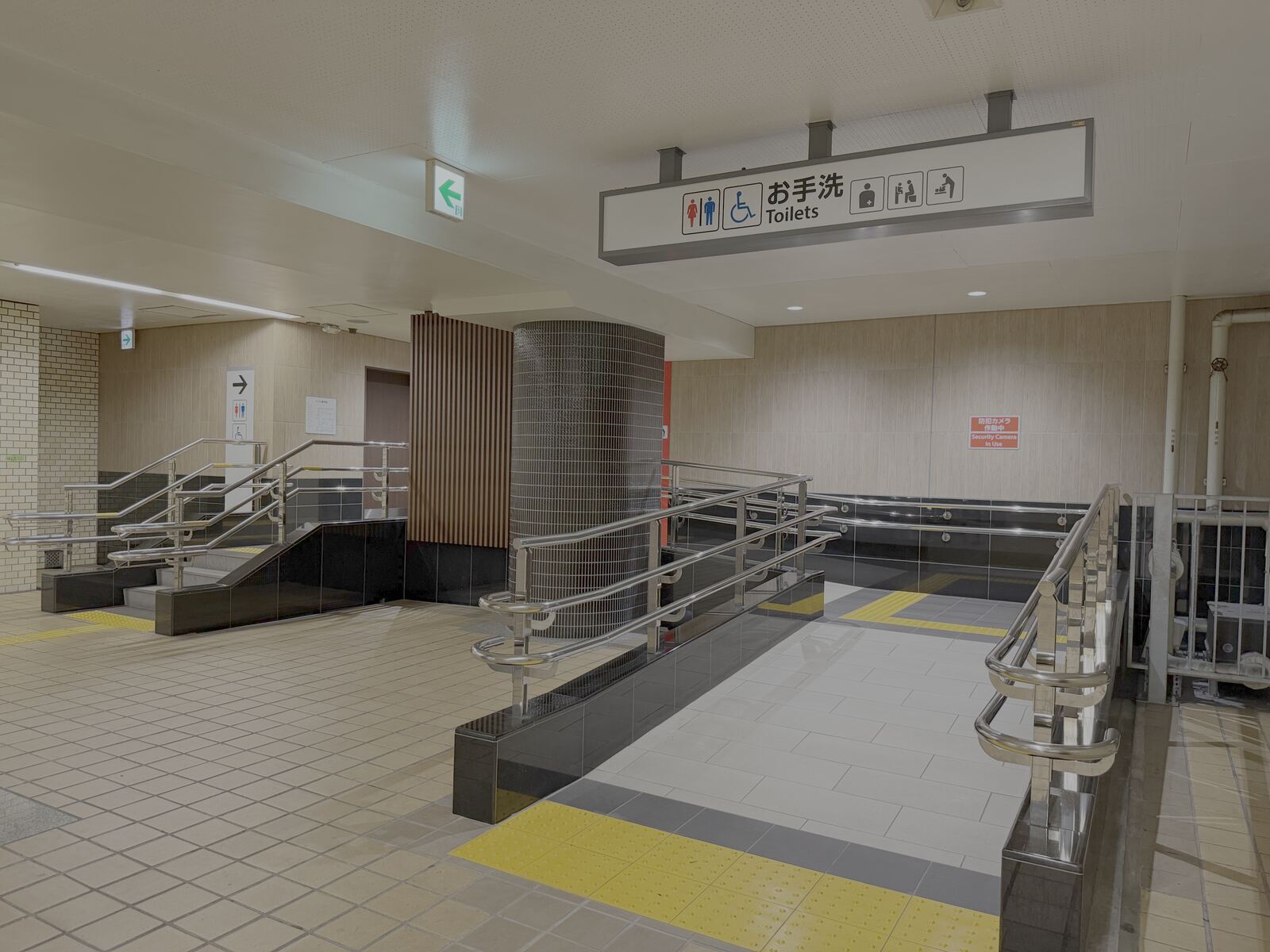 Overhead Toilets sign with wheelchair and accessible pictograms, next to a ramp with handrails at Osu Kannon Station.